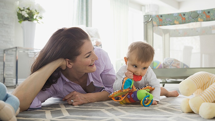 kobieta leżąca z dzieckiem na dywanie