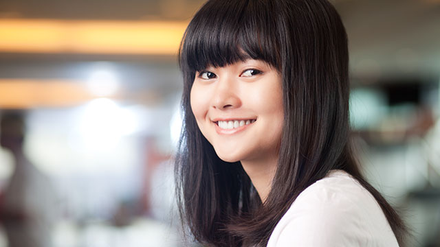 młoda kobieta uśmiechnięta w pomieszczeniu