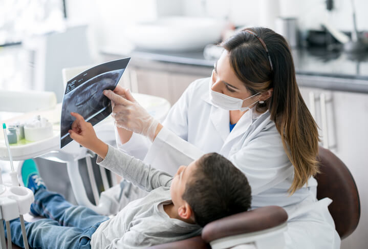 Dentysta z dzieckiem w gabinecie stomatologicznym