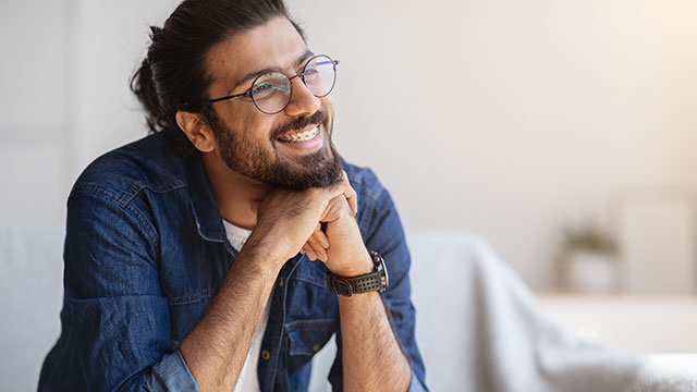 młody mężczyzna uśmiecha się z aparatami na zębach