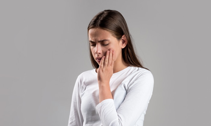 Kobieta trzymająca się za policzek