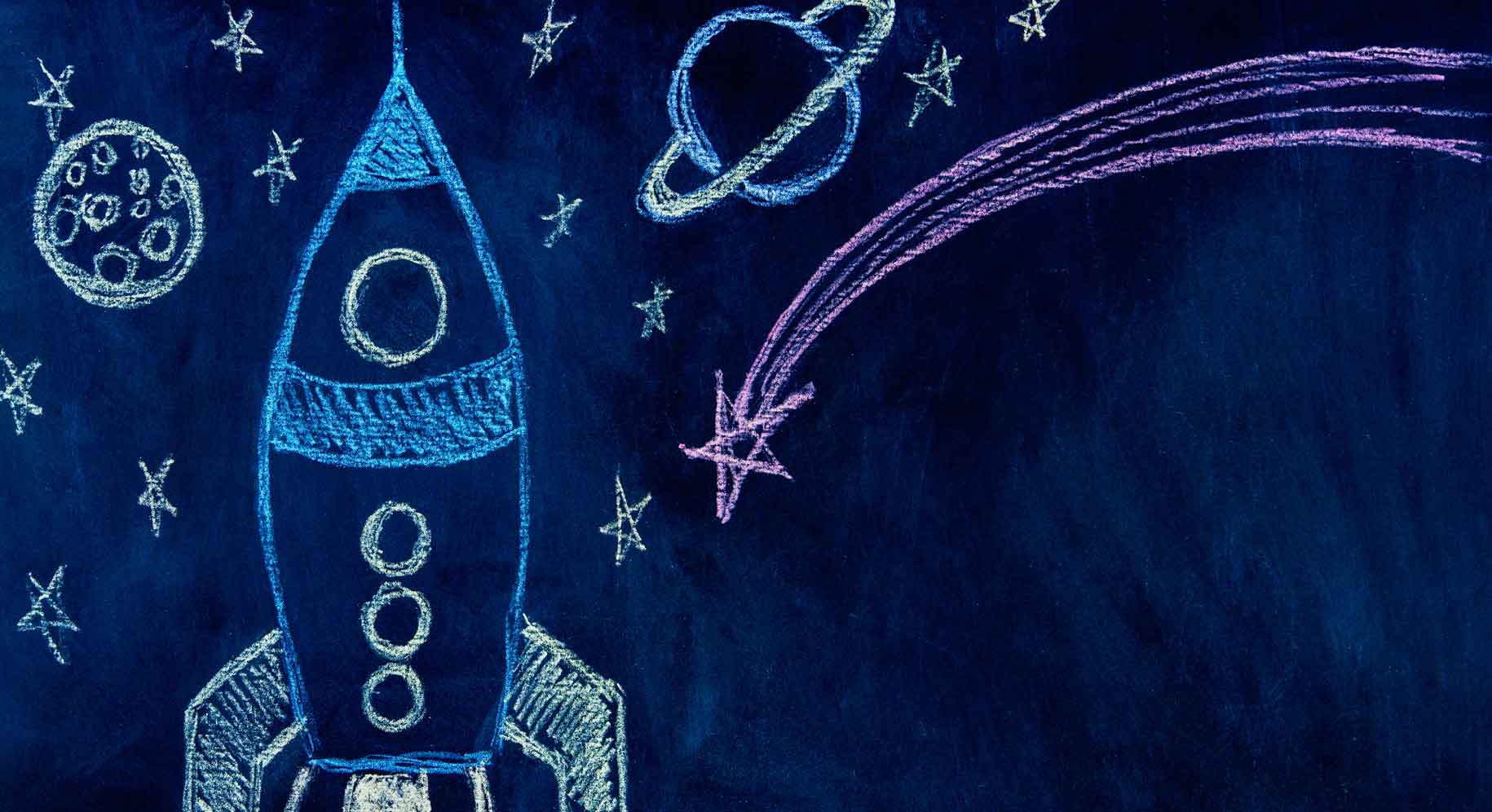 Granatowe tło z narysowaną przez dziecko rakietą kosmiczną, gwiazdami, Saturnem i Marsem.