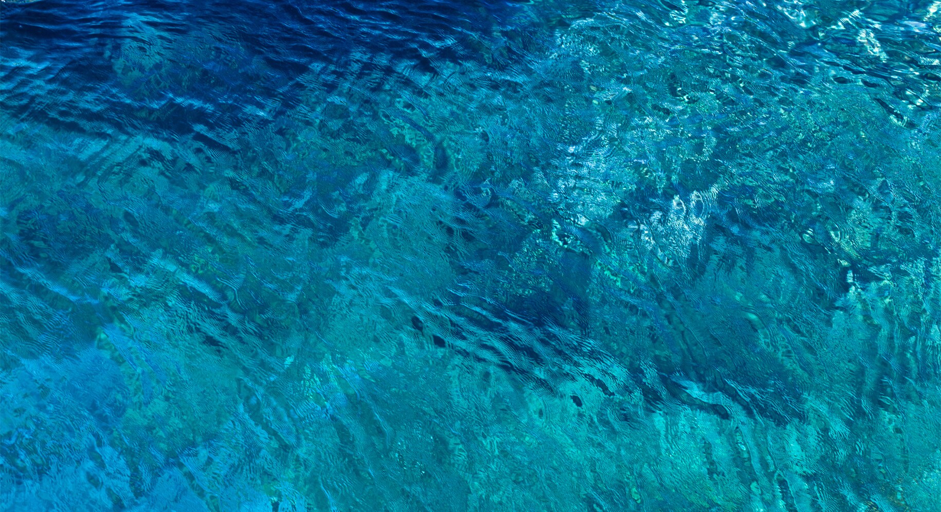 Niewielkie fale przepływające przez czyste niebieskie wody morskie.