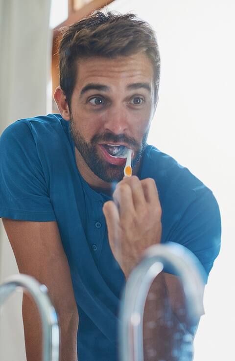 man using colgate toothbrush man using colgate toothbrush